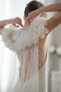robe de mariée decolletée dans le dos et cape en tulle de soie